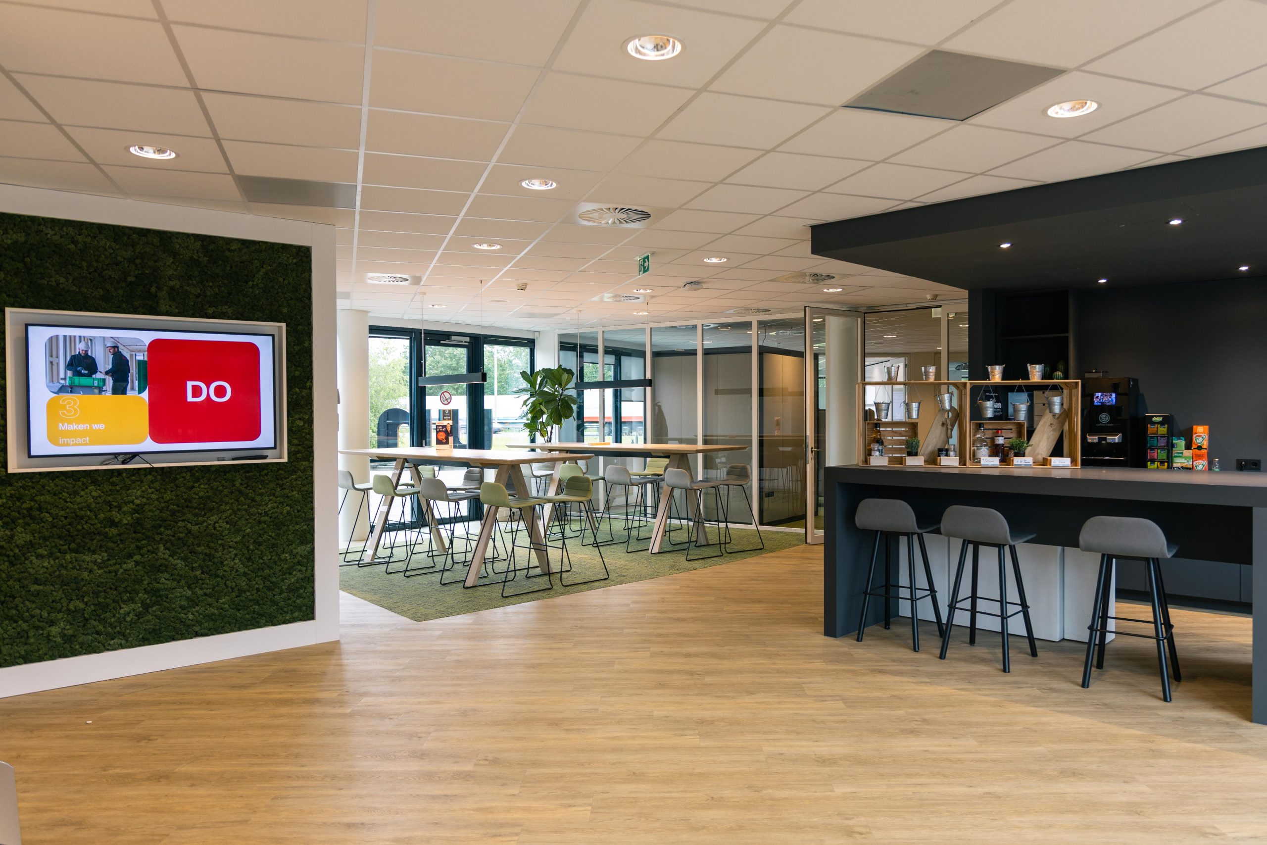 Unica employee walking past a digital signage screen - DST Connect internal communication